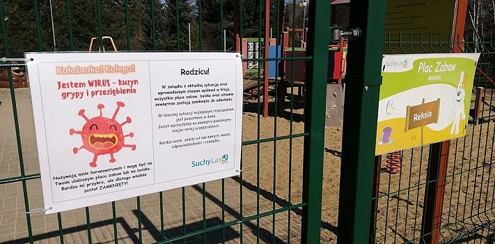 Widok na ogrodzenie placu zabaw imienia Reksia, na którym została zawieszona informacja o zamknięciu placów zabaw, boisk i siłowni zewnętrznych