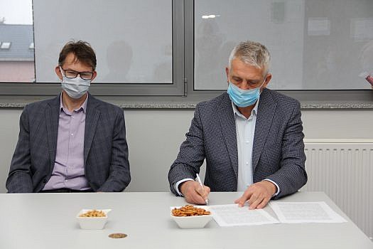 Wójt Grzegorz Wojtera podpisuje umowę a zakup działki, po jego prawej strone siedzi zastępca wójta Marcin Bulińśki