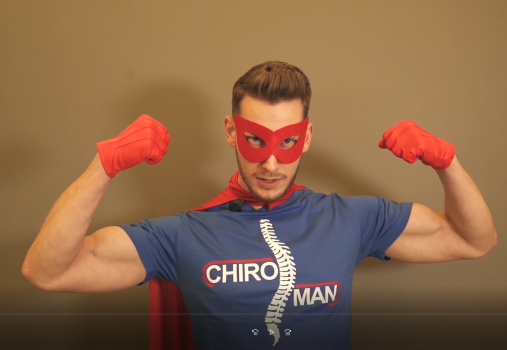 Mężczyzna przebrany za super bohatera w koszulce z napisem Chiro Man, na której znajduje sie też szkielet kręgosłupa.