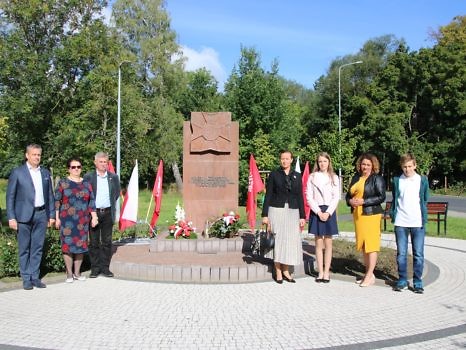 Mlodzież i osoby dorosłe stojące po obu stronach pomnika 7 Pułku Strzelców Konnych w Biedrusku.