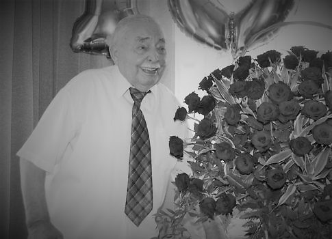Ludwik Marciniak w otoczeniu kosza czerwonych róż.