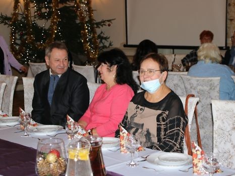 Trzy osoby siedzące przy stole.