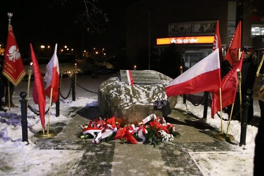 Głaz w Suchym Lesie upamiętniający powstanie wielkopolskie w otoczeniu flag.