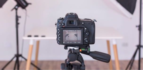 Pomieszczenie fotografa z aparatem i lampami do robienia zdjęć.