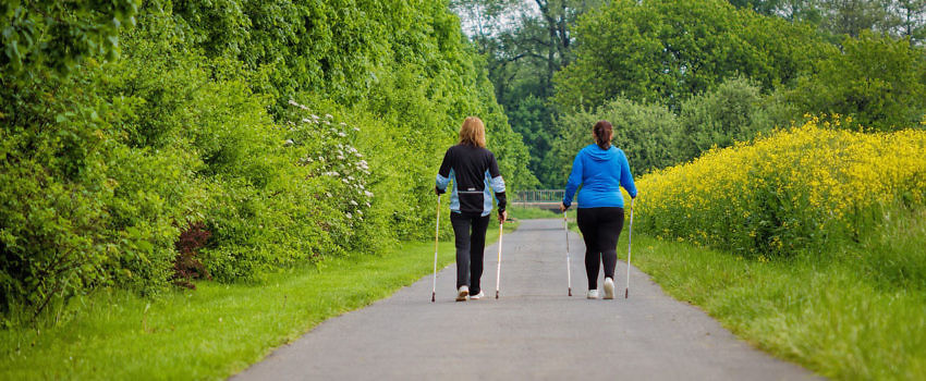 dwie panie maszerujące z kijkami nordic walking
