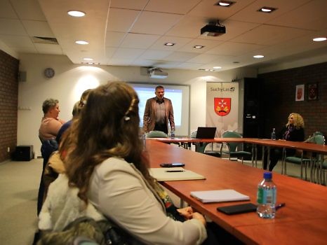 Widok na uczestników szkolenia i prowadzącego w sali konferencyjnej.