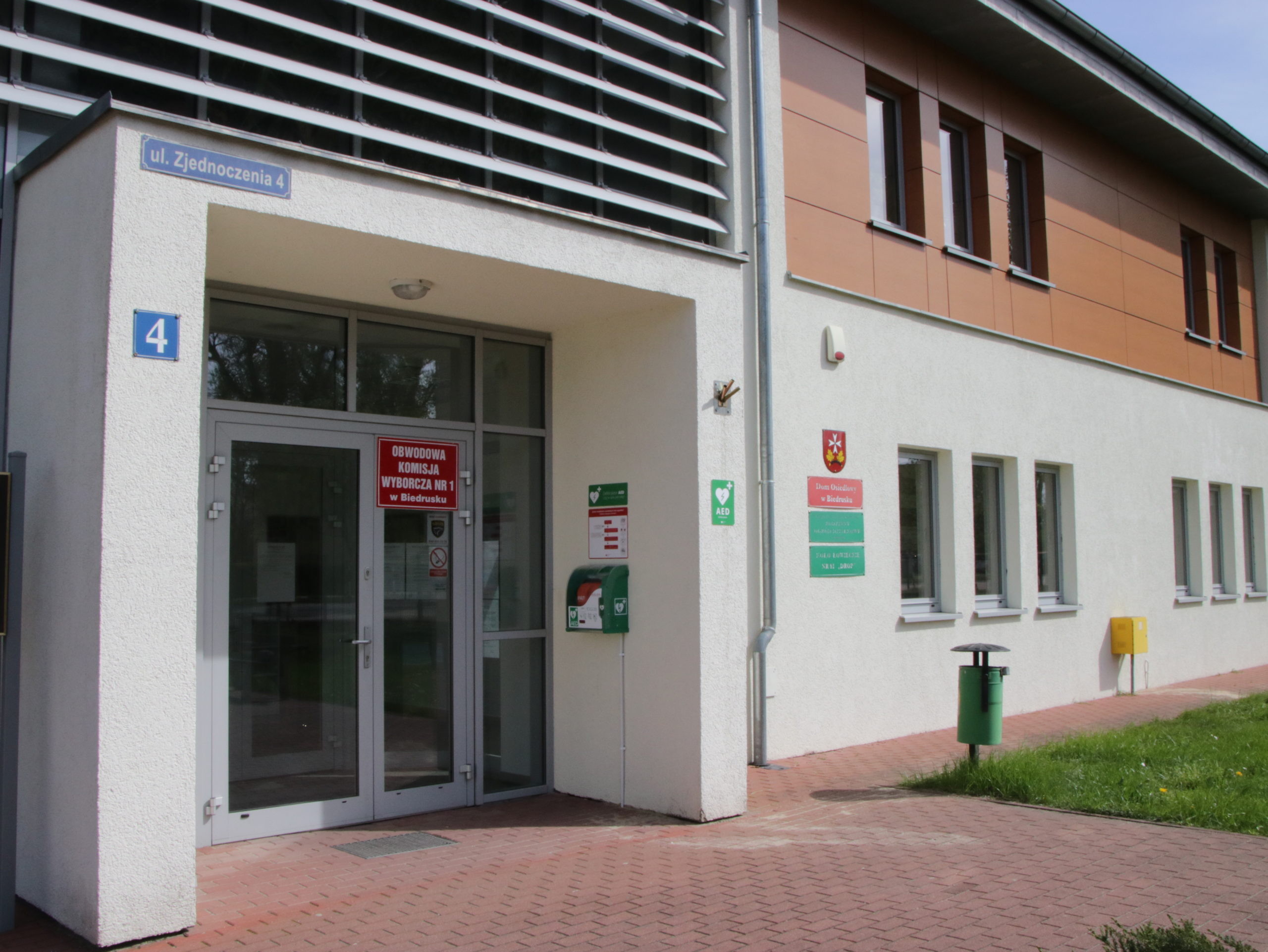 Widok na front Domu Osiedlowego, gdzie zawieszone jest AED. 