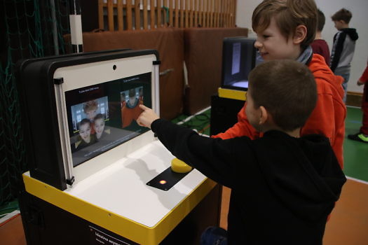 Zdjęcie dwóch chłopców siedzących przed monitorem.