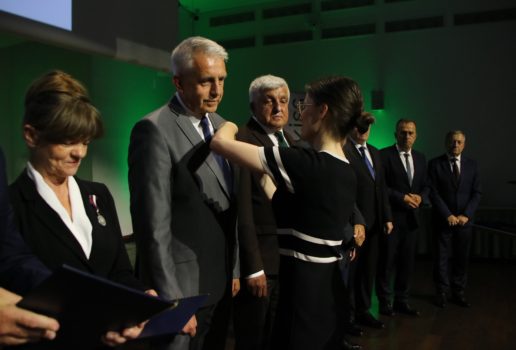 Wojewoda Wielkopolska przypina odznaczenie wójtowi gminy.