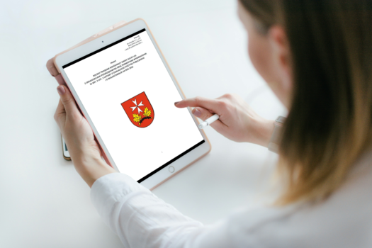 Zdjęcie kobiety trzymającej w ręku tablet, na którym wyświetlony jest roczny program współpracy.