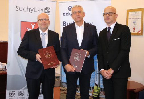 Wójt z dwoma przedstawicielami firmy, która będzie budować szkołę na tle roll upów.