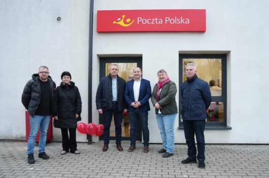 Uczestnicy spotkania przed budynkiem nowej siedziby Poczty Polskiej.