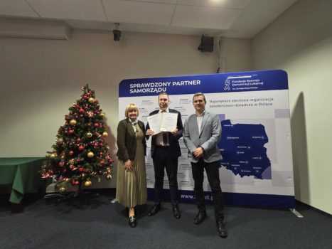 Na zdjęciu Sekretarz Gminy pozujący z przyznanymi nagrodami.