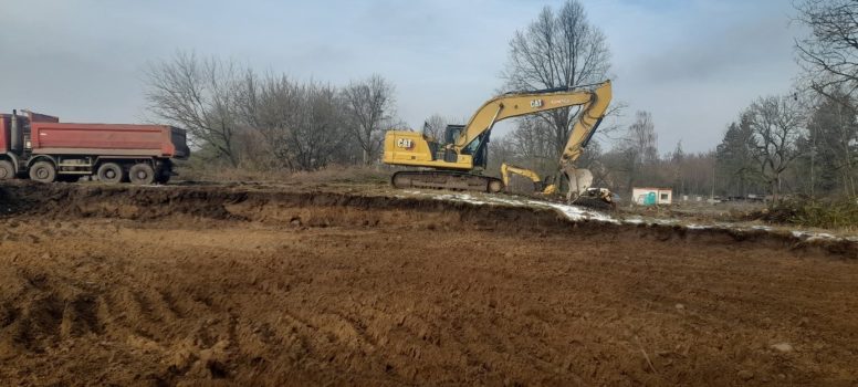 Plac budowy szkoły z koparką.
