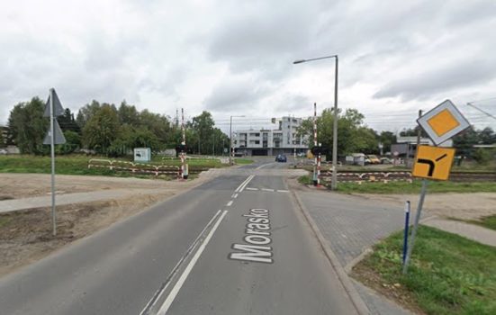 Widok na przejazd kolejowy z rogatkami.