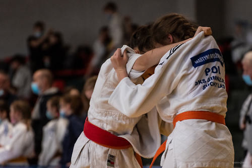 Zbliżenie na dwóch zakleszczonych ze sobą zawodników judo podczas walki.